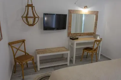 a room with a mirror and a table and chairs at Rafael Hotel-Adults Only in Líndos