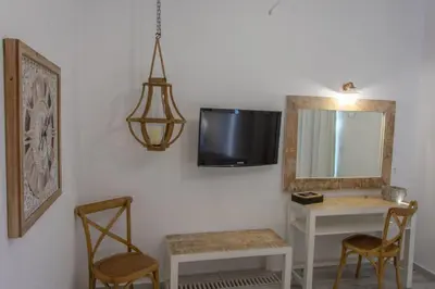 a room with a mirror and a table and chairs at Rafael Hotel-Adults Only in Líndos