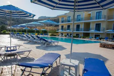 a group of chairs and umbrellas next to a swimming pool at Rafael Hotel-Adults Only in Líndos