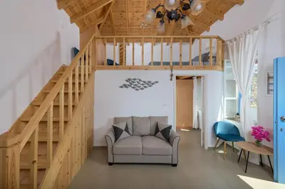 a living room with a staircase and a couch at Anastasia house in Halki
