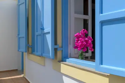 a vase of pink flowers sitting in a window at Anastasia house in Halki