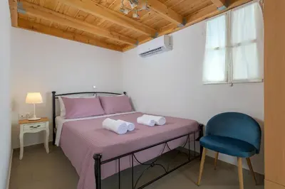 a bedroom with a bed and a blue chair at Anastasia house in Halki