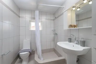 a white bathroom with a sink and a toilet at Anastasia house in Halki
