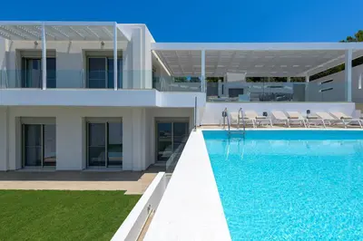 a villa with a swimming pool in front of a house at Villa Dione in Pefkos, Lindos area in Líndos