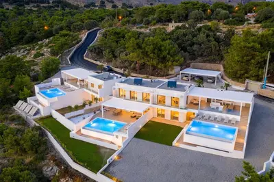 an aerial view of a house with two swimming pools at Villa Dione in Pefkos, Lindos area in Líndos
