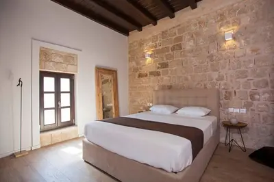 a bedroom with a large bed and a brick wall at Casa Quindici in the Old Town in Rhodes Town