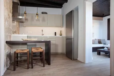 a kitchen with a table and some chairs and a refrigerator at Casa Quindici in the Old Town in Rhodes Town