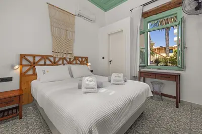 a bedroom with a white bed and a window at Casa del Sol Suites in Rhodes Town