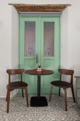 a table and two chairs in a room with green walls at Casa del Sol Suites in Rhodes Town