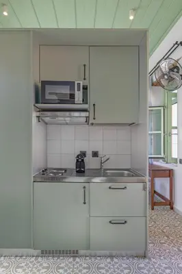 a kitchen with a sink and a microwave at Casa del Sol Suites in Rhodes Town