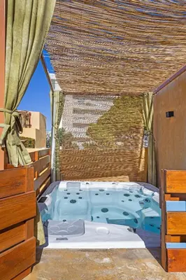 a jacuzzi tub in a room with a window at Casa del Sol Suites in Rhodes Town