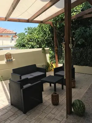 a patio with two chairs and a pergola at villa62rodos in Kremasti