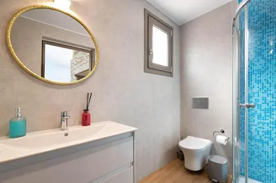 a bathroom with a sink and a mirror and a toilet at Ikaros Villa in Pefki Rhodes