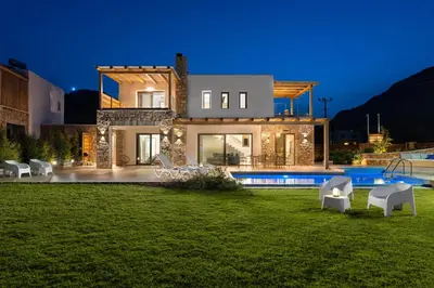 a villa with a swimming pool at night at Ikaros Villa in Pefki Rhodes