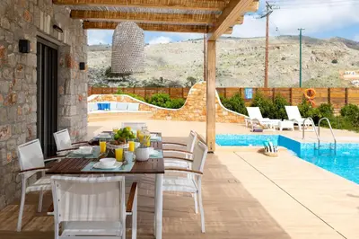 a patio with a table and chairs and a pool at Ikaros Villa in Pefki Rhodes