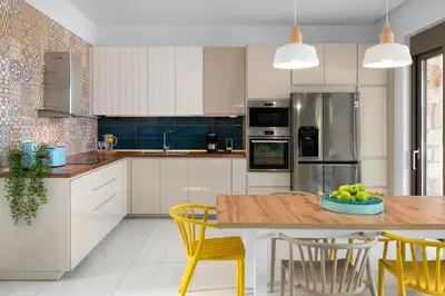 a kitchen with a wooden table and yellow chairs at Ikaros Villa in Pefki Rhodes