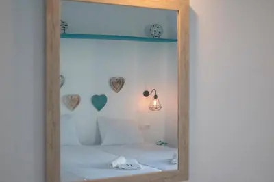 a mirror in a bedroom with hearts on the wall at Haraki Sea & Sun in Haraki