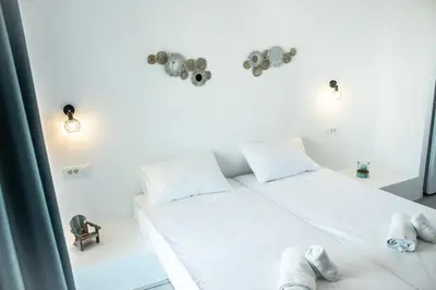 a bedroom with a white bed with towels on it at Haraki Sea & Sun in Haraki