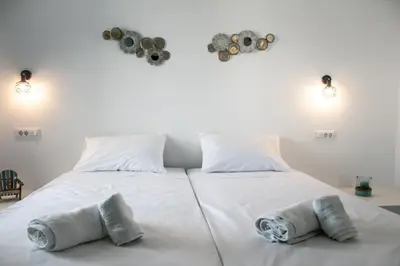 a large white bed with two pillows on it at Haraki Sea & Sun in Haraki