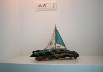 a model of a sail boat on a piece of wood at Haraki Sea & Sun in Haraki