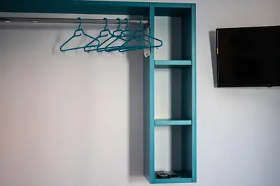 a blue book shelf with a tv and a shelf at Haraki Sea & Sun in Haraki