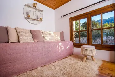 a living room with a pink couch and a stool at Old Nest House in Sálakos