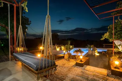 a hammock on a patio at night at Old Nest House in Sálakos