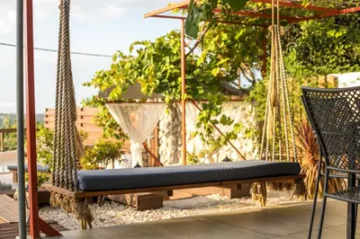 a hammock and a chair on a patio at Old Nest House in Sálakos
