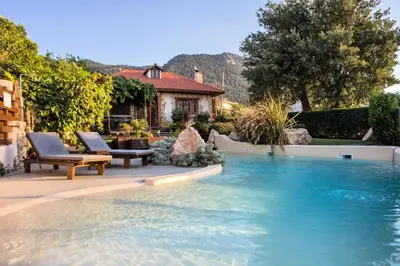 a swimming pool with two chairs and a house at Old Nest House in Sálakos