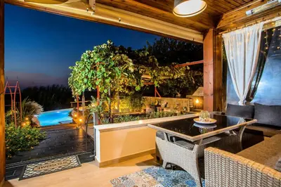 a patio with a table and chairs and a pool at Old Nest House in Sálakos