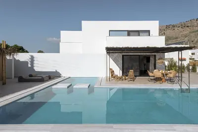 a swimming pool with chairs and a house at Bianco Villa - Eve in Pefki Rhodes