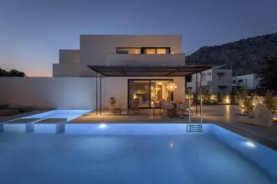 a villa with a swimming pool in front of a house at Bianco Villa - Eve in Pefki Rhodes