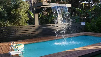 a swimming pool with a fountain in a backyard at Villa Astravi in Ialyssos