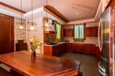 a kitchen with a wooden table with flowers on it at Villa Astravi in Ialyssos