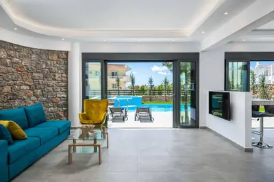 a living room with a blue couch and a tv at Villa Summer Dawn in Kiotari