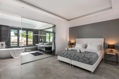 a bedroom with a large bed and a bath tub at Villa Summer Dawn in Kiotari