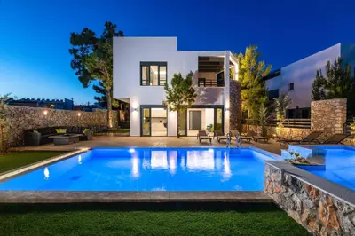 a swimming pool in front of a house at night at Villa Summer Dawn in Kiotari