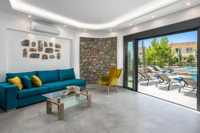 a living room with a blue couch and a patio at Villa Summer Dawn in Kiotari