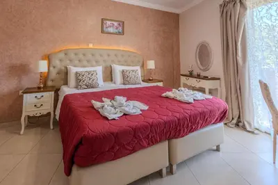 a bedroom with a large bed with a red blanket at Knights' Castle Studios in Archangelos