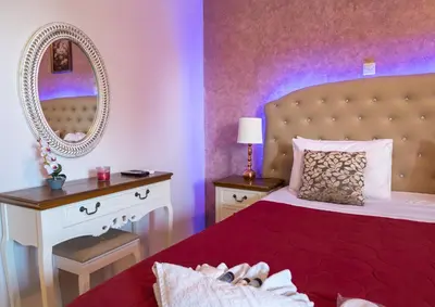 a bedroom with a bed and a vanity with a mirror at Knights' Castle Studios in Archangelos
