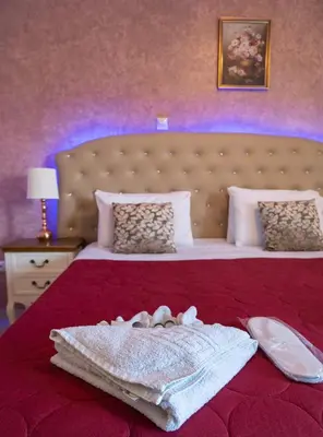 a bedroom with a large bed with a red bedspread at Knights' Castle Studios in Archangelos