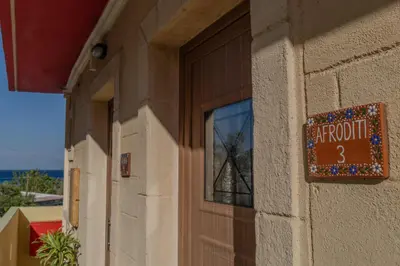 a sign on the side of a building with a window at Knights' Castle Studios in Archangelos