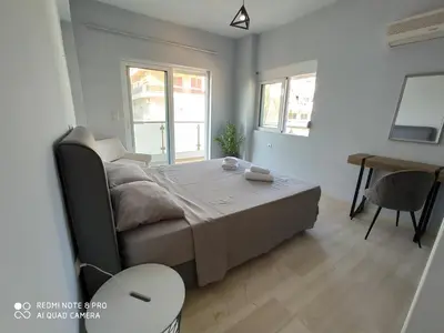 a bedroom with a bed and a table and a desk at Elli beach apartment top location Rodos in Rhodes Town