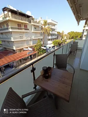 a table on a balcony with a view of a building at Elli beach apartment top location Rodos in Rhodes Town