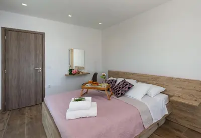 a bedroom with a large bed with a wooden headboard at Rosemary Rhodes Villa in Malona Village
