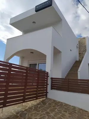 a house with a wooden fence and a staircase at Rosemary Rhodes Villa in Malona Village