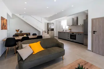 a living room with a couch and a kitchen at Rosemary Rhodes Villa in Malona Village
