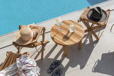 a table with a hat and chairs next to a pool at Bianco Villa - Adam in Pefki Rhodes