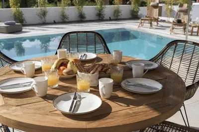 a wooden table with food on it next to a pool at Bianco Villa - Adam in Pefki Rhodes