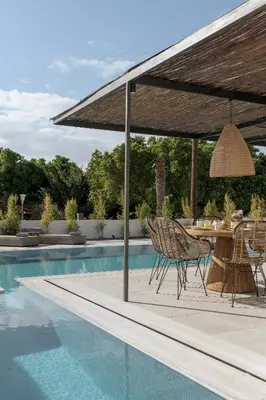 a patio with a table and chairs next to a pool at Bianco Villa - Adam in Pefki Rhodes
